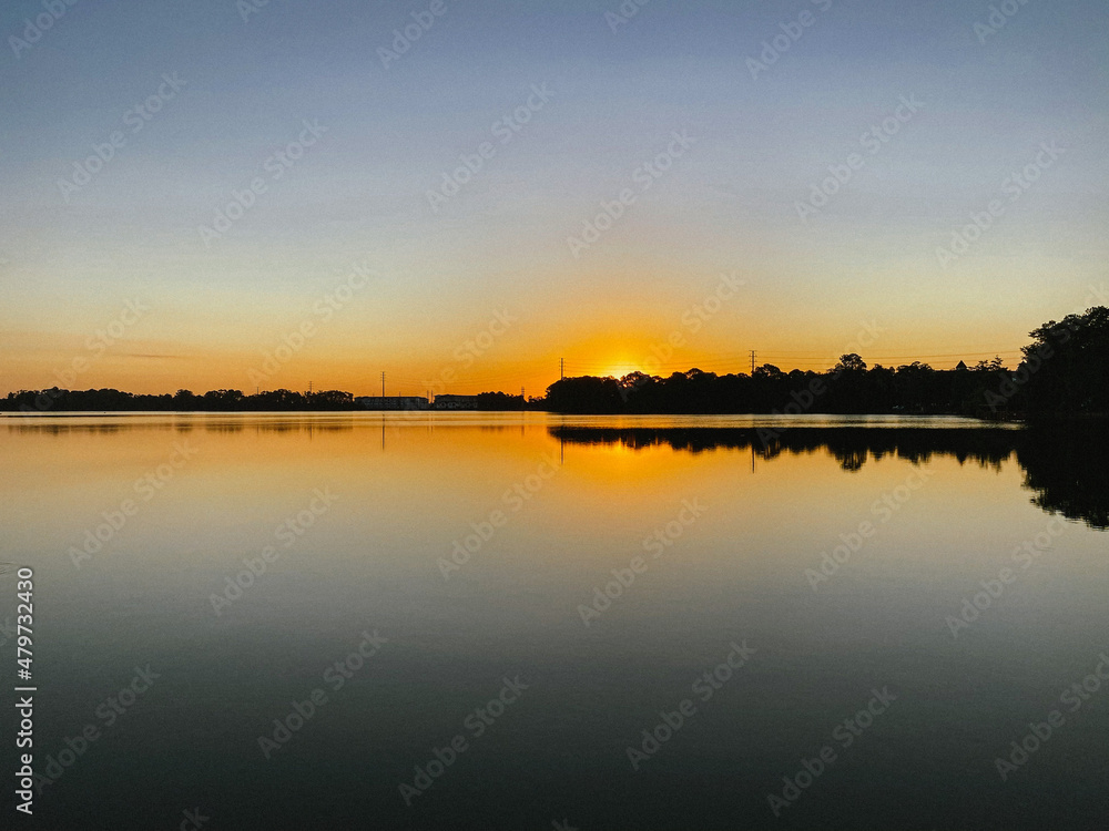 Sunrise reflection on the horizon over lake