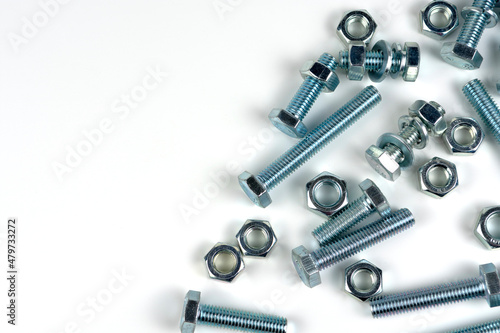 several bolts with nuts made of silver metal. Close-up isolated on a white background. Copy space