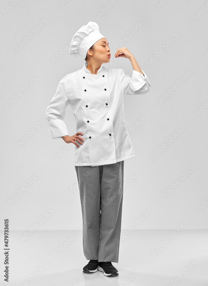 cooking, culinary and people concept - happy female chef showing gourmet sign over grey background cooking, culinary and people concept - happy female chef showing gourmet sign over grey background
