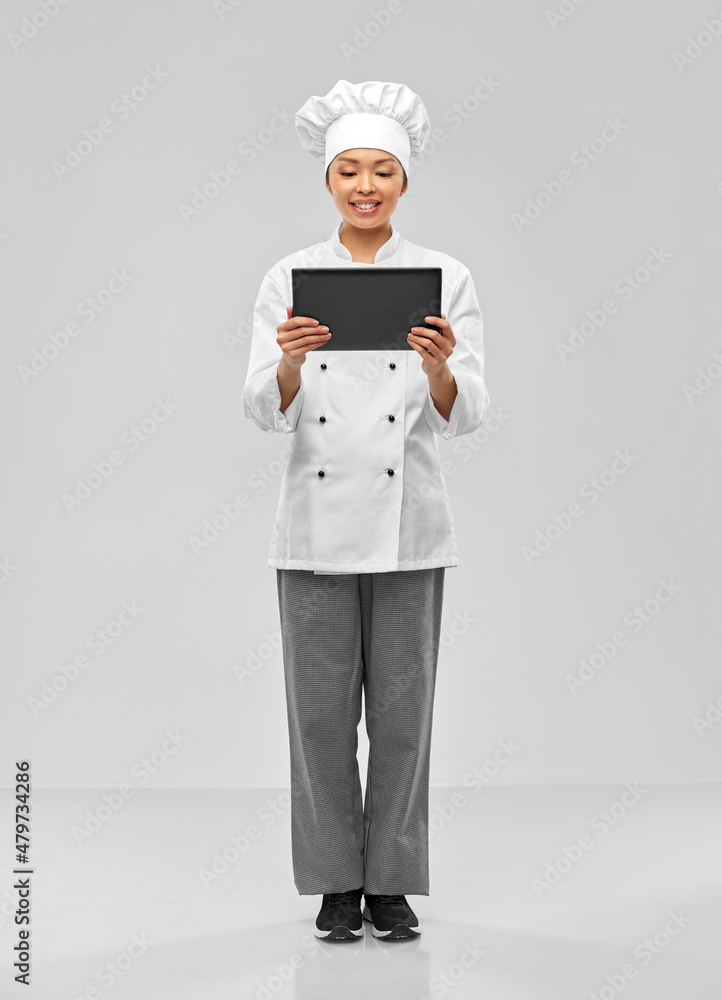 cooking, culinary and people concept - happy smiling female chef with tablet pc computer over grey background cooking, culinary and people concept - happy smiling female chef with tablet pc computer over grey background
