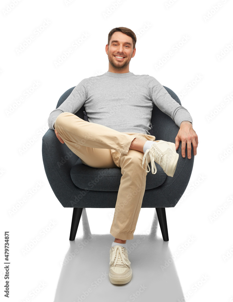 people and furniture concept - happy smiling man sitting in chair over white background people and furniture concept - happy smiling man sitting in chair over white background