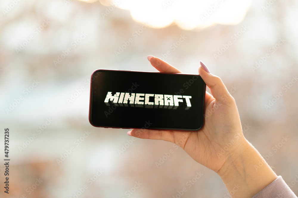 Hands holding a smartphone with Minecraft Pocket Edition game on ...