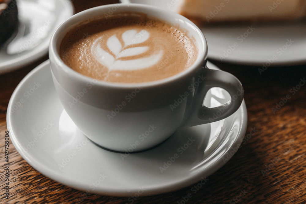 A cup of cappuccino on a wooden table. A cup of cappuccino on a wooden table.