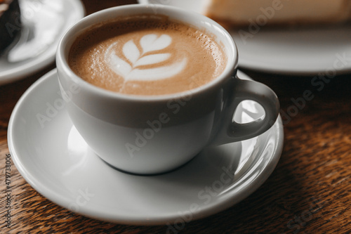 A cup of cappuccino on a wooden table.