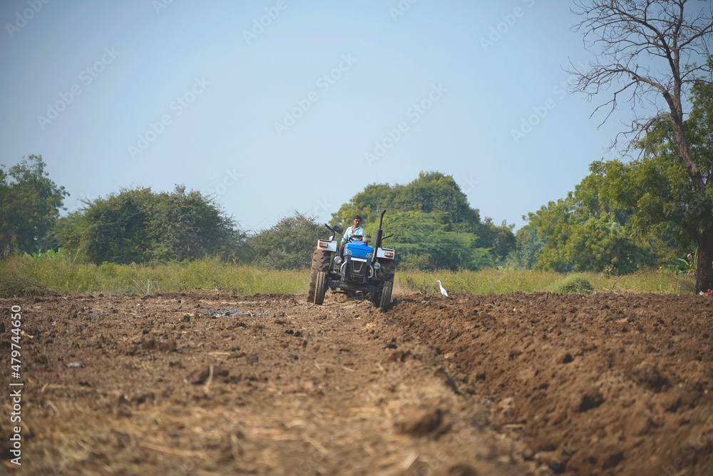 Indian farmer working with tractor in agriculture field. Indian farmer working with tractor in agriculture field.
