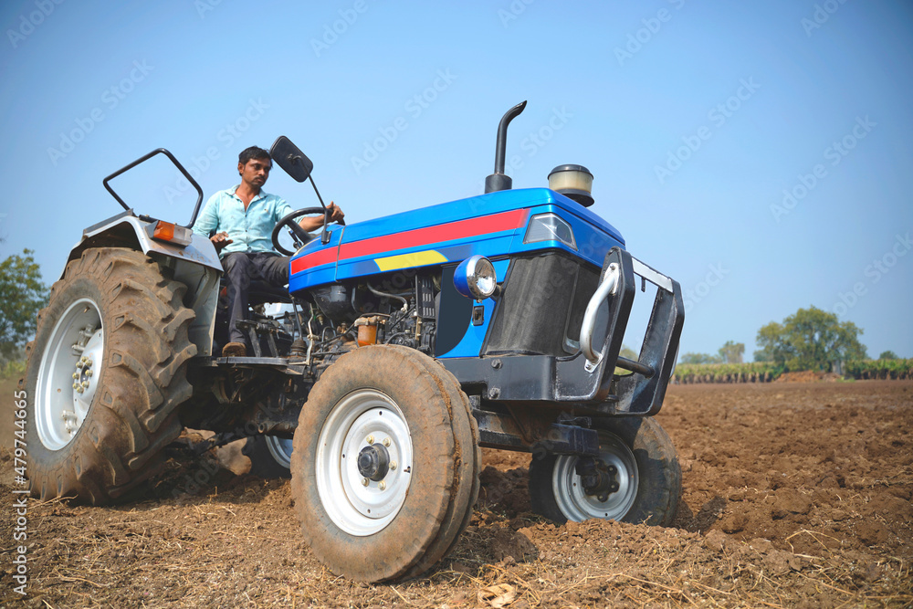 Indian farmer working with tractor in agriculture field. Indian farmer working with tractor in agriculture field.