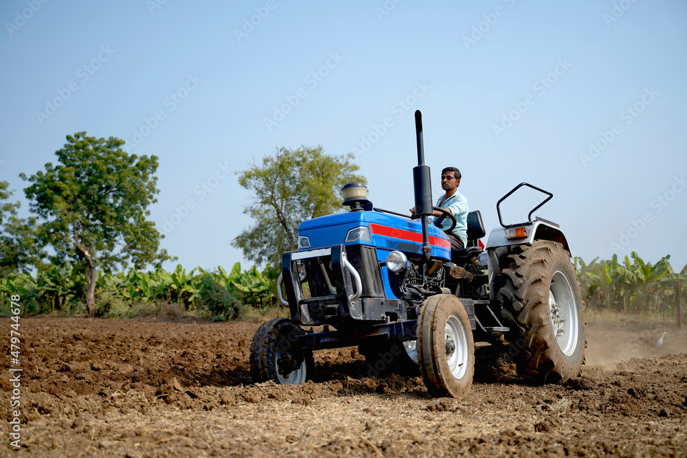 Indian farmer working with tractor in agriculture field. Indian farmer working with tractor in agriculture field.