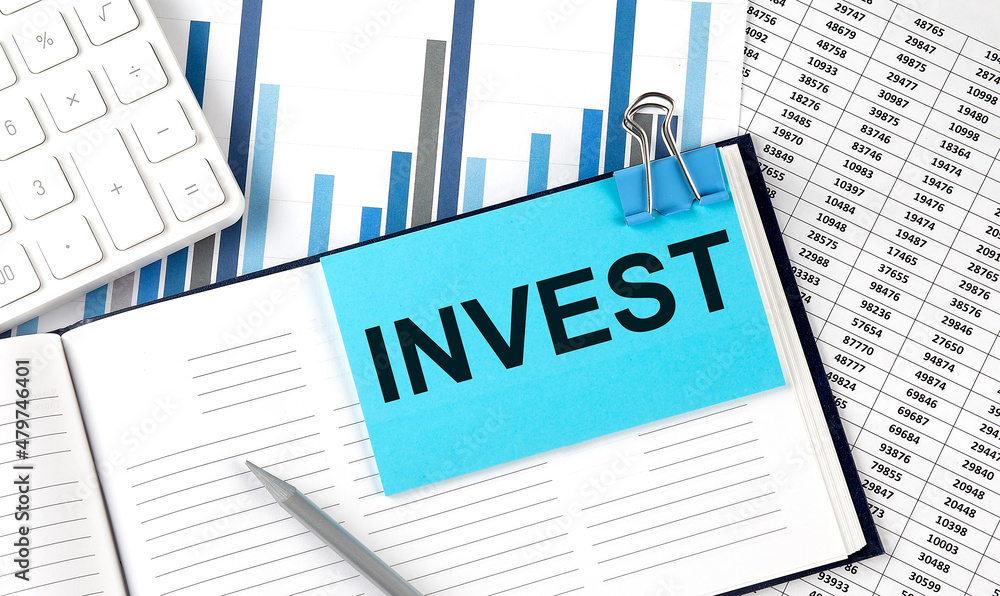 INVEST text on blue sticker on the chart background near calculator INVEST text on blue sticker on the chart background near calculator