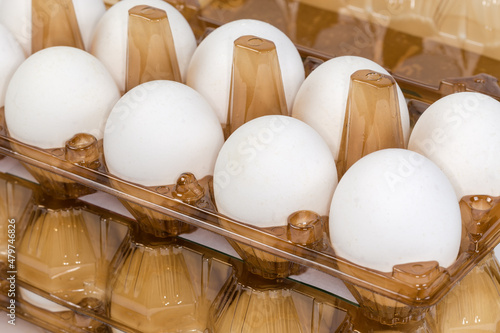 Chicken eggs in plastic egg packaging trays, fragment close-up photo