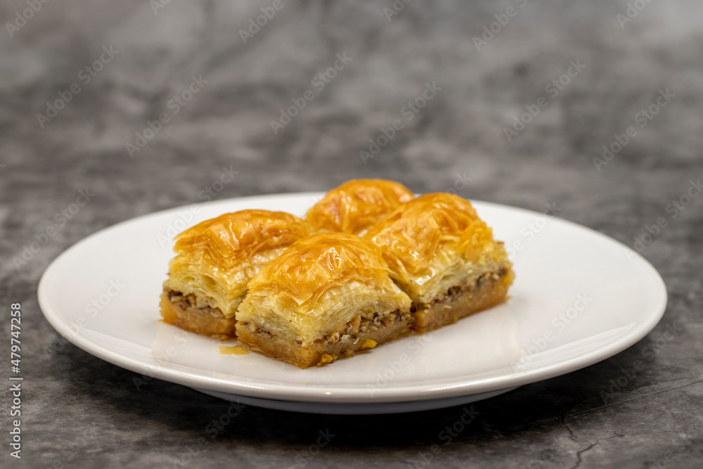 Walnut baklava on a dark background. Traditional Turkish cuisine delicacies. Close-up. Walnut baklava on a dark background. Traditional Turkish cuisine delicacies. Close-up.