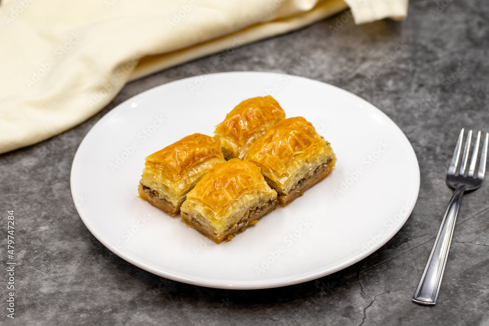 Walnut baklava on a dark background. Traditional Turkish cuisine delicacies. Close-up. Walnut baklava on a dark background. Traditional Turkish cuisine delicacies. Close-up.