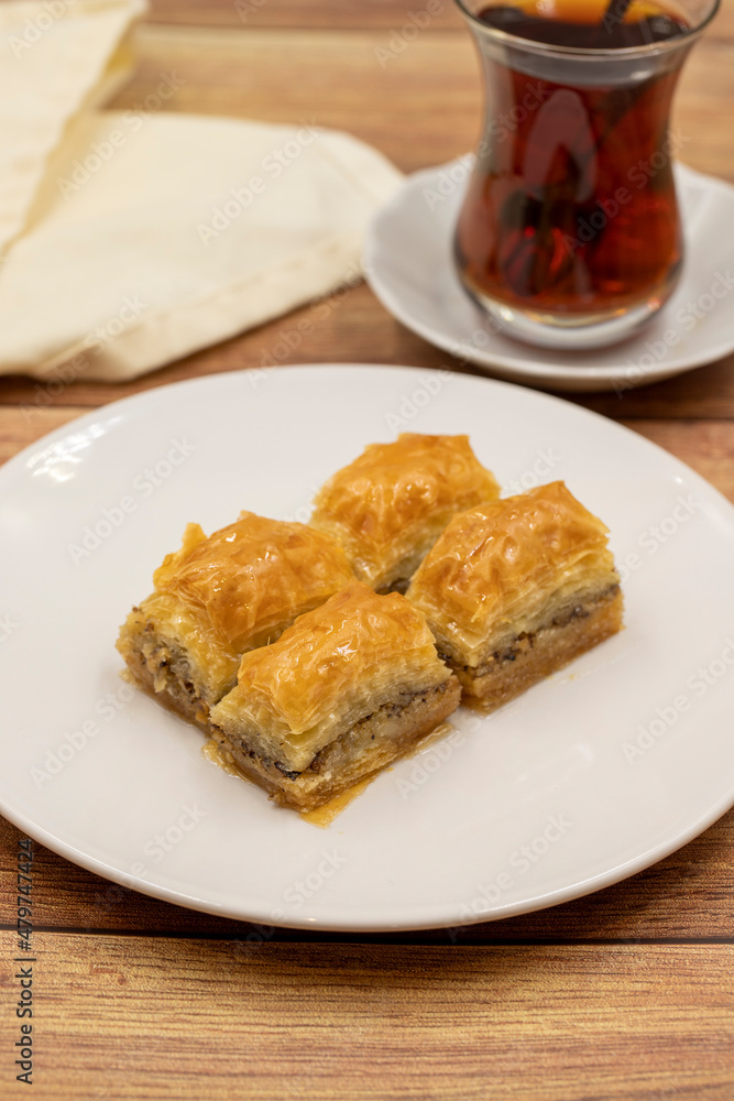Walnut baklava on a wooden background. Traditional Turkish cuisine delicacies. Close-up. Walnut baklava on a wooden background. Traditional Turkish cuisine delicacies. Close-up.