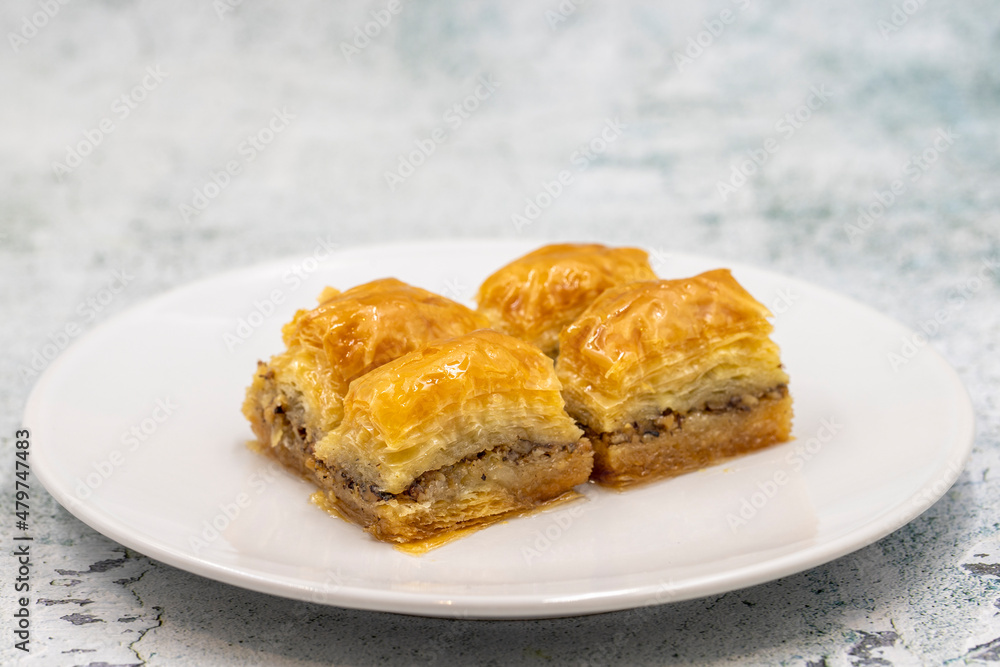 Walnut baklava on a stone background. Traditional Turkish cuisine delicacies. Close-up. Walnut baklava on a stone background. Traditional Turkish cuisine delicacies. Close-up.