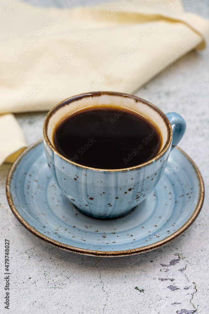 A cup of coffee on stone background. Close-up. A cup of coffee on stone background. Close-up.