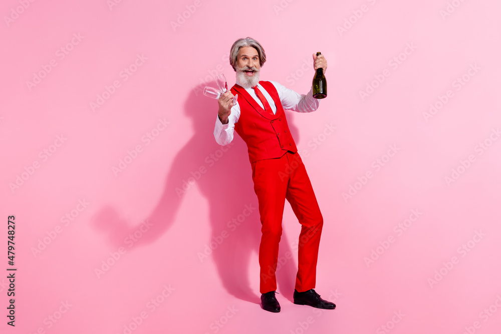 Full length body size view of attractive cheery grey-haired man drinking wine anniversary having fun isolated over pink pastel color background Full length body size view of attractive cheery grey-haired man drinking wine anniversary having fun isolated over pink pastel color background