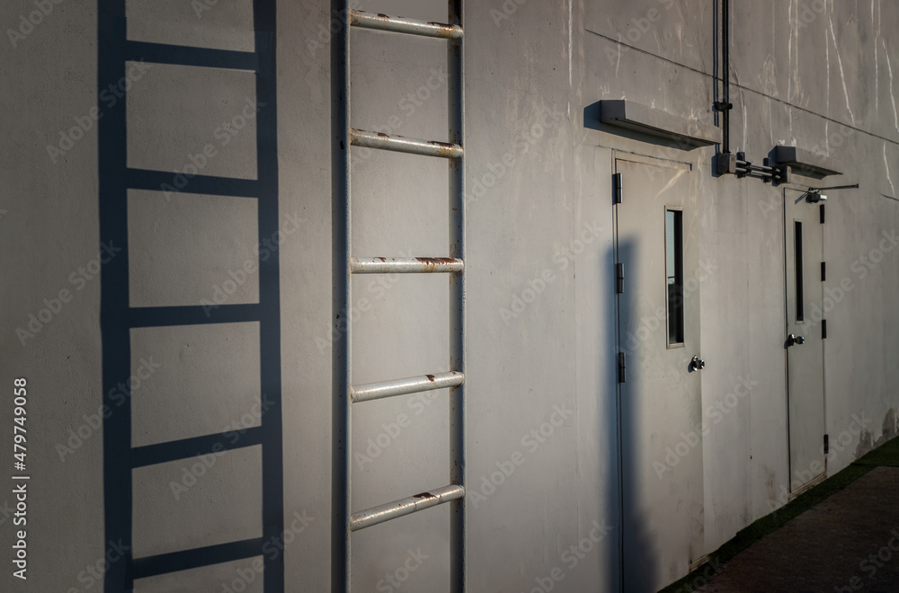 White metal fire escape attached and Two doors to a wall and leading to the roof of a building. Copy space, No focus, specifically White metal fire escape attached and Two doors to a wall and leading to the roof of a building. Copy space, No focus, specifically