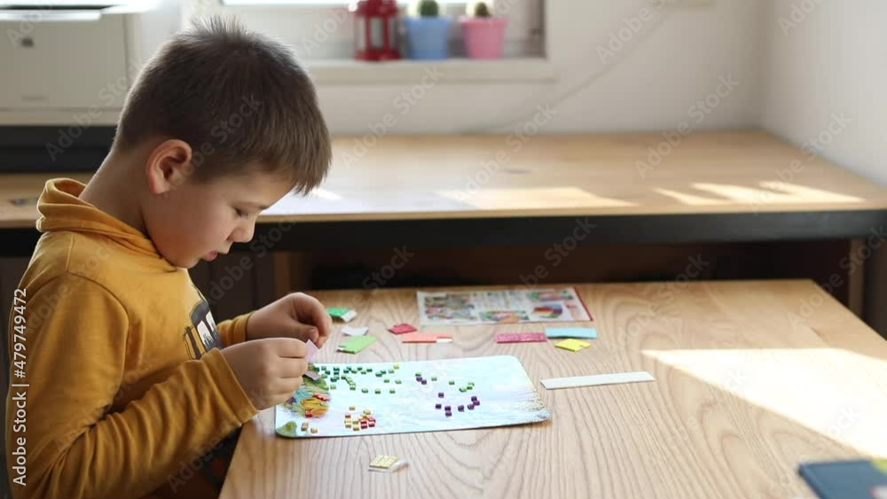 Little boy being creative making homemade do it yourself dinosaur mosaic. Little boy being creative making homemade do it yourself dinosaur mosaic.