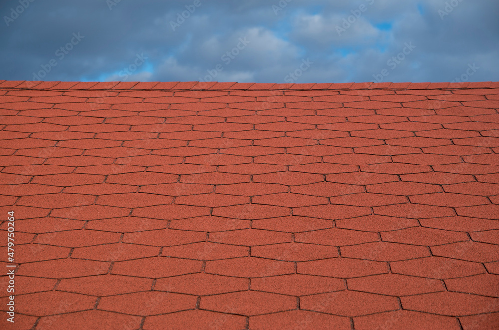Roof with new red bitumen shingles close Roof with new red bitumen shingles close