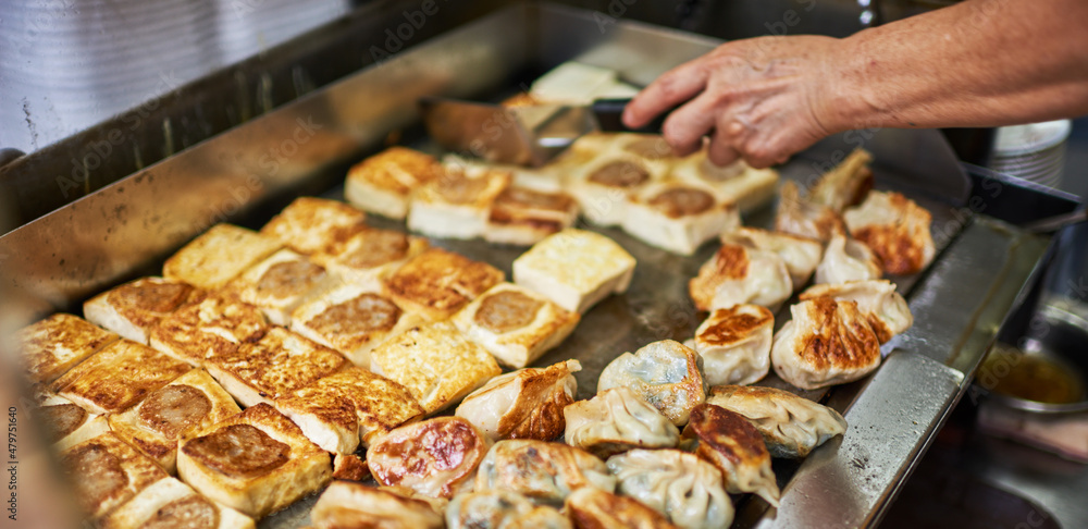 Woman hand reaching for a deep fried spring roll at food truck. Close up of food truck salesman serving street to customer. Asian street food , catering service. Woman hand reaching for a deep fried spring roll at food truck. Close up of food truck salesman serving street to customer. Asian street food , catering service.