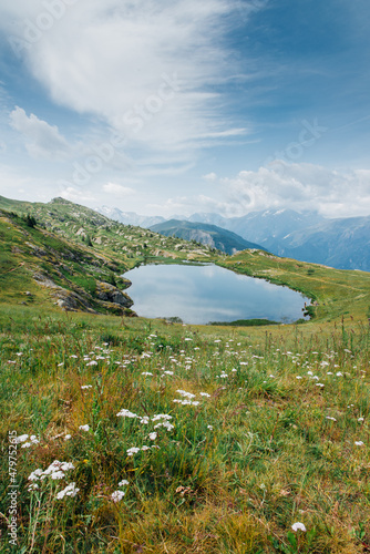 Fototapeta Naklejka Na Ścianę i Meble -  Un paysage de montagnes. Un lac dans les Alpes. Un lac de montagnes. Les Alpes en été. Une prairie alpine avec un lac.