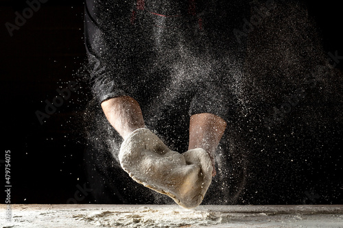 Tablou pe pânză Beautiful and strong men's hands knead the dough make bread, pasta or pizza