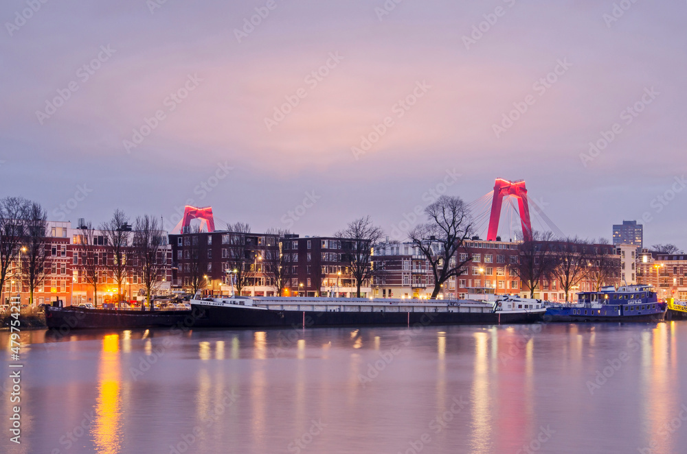 Rotterdam, The Netherlands, January 10, 2022: the red pylons of Willems bridge rise above the houses and barges at Noordereiland neighbourhood