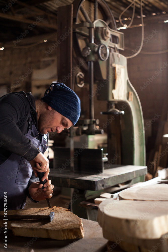 Young male carpenter working in his workshop using tools Young male carpenter working in his workshop using tools