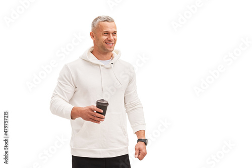 Men holding coffee in hand standing isolated white background studio shoot. Caucasian handsome male dressed white hoodie looking away positive emotions teeth smiling.