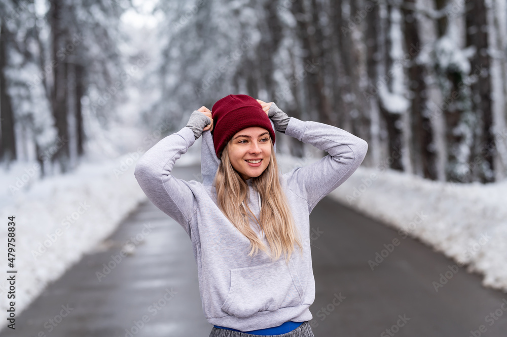 Sportswoman standing in nature on a snowy winter day. Portrait of a beautiful young fitness woman in the snow. Sportswoman standing in nature on a snowy winter day. Portrait of a beautiful young fitness woman in the snow.