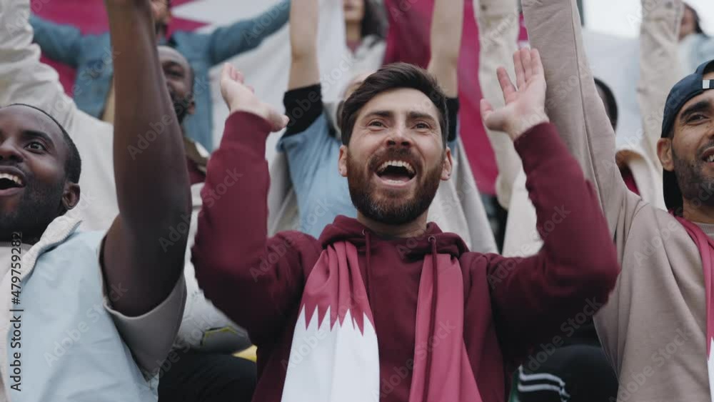 Man screaming and raising hands together during soccer game Man screaming and raising hands together during soccer game