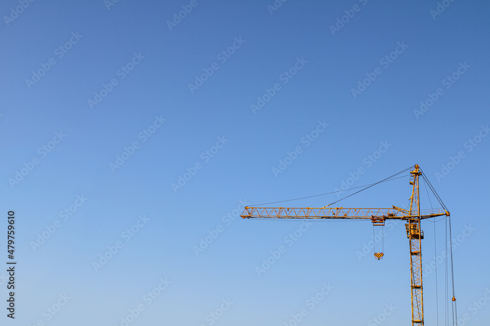 part of a contrasting yellow construction crane against a large clear sky business background for building architect orders part of a contrasting yellow construction crane against a large clear sky business background for building architect orders