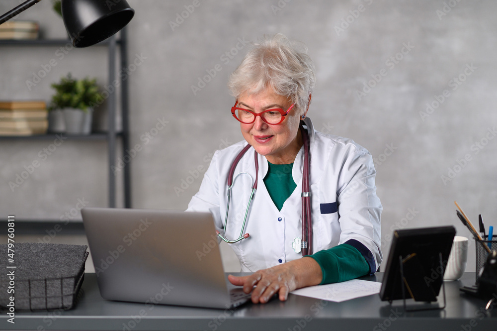 Middle age female doctor using laptop, writing notes with stethoscope on table. Healthcare concept. Medical doctor writing and taking notes Middle age female doctor using laptop, writing notes with stethoscope on table. Healthcare concept. Medical doctor writing and taking notes