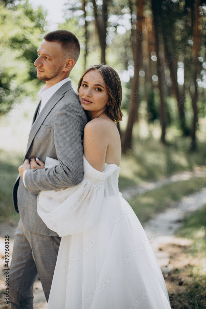Young couple having wedding photo session in forest on their wedding day Young couple having wedding photo session in forest on their wedding day