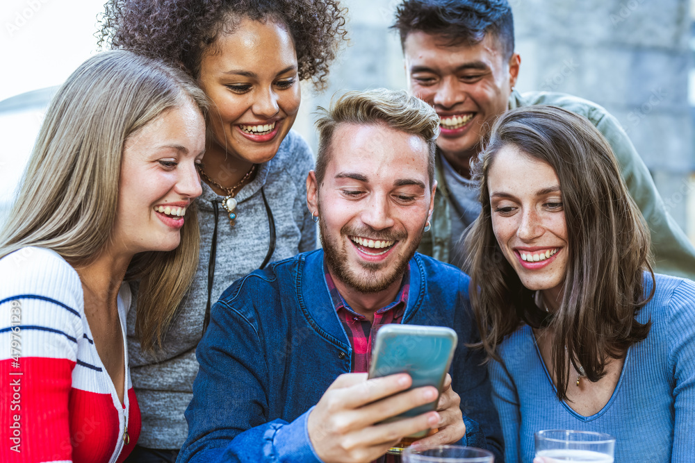 Fototapeta premium group of multiracial friends having fun using social network, tech people and young influencer creating digital content with smart phone and mobile app