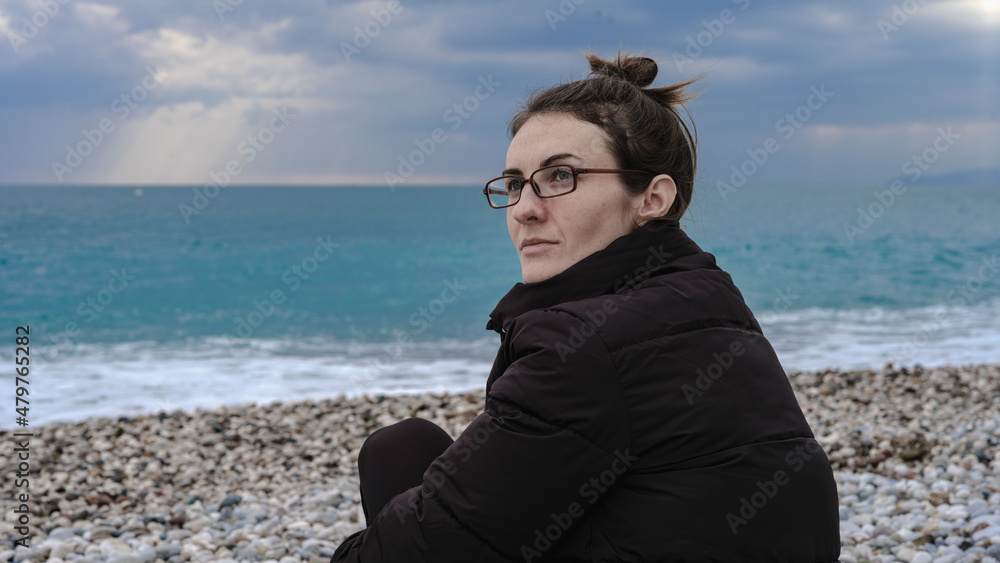 beautiful woman sitting alone on the beach