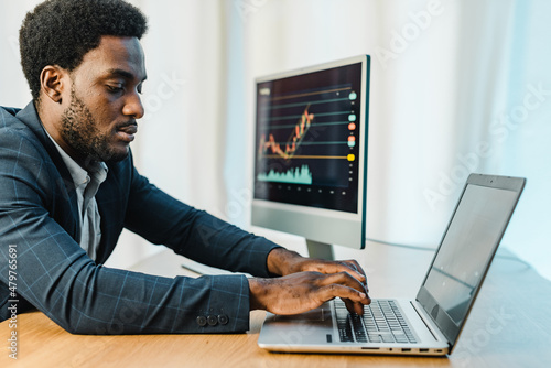 Focused male trader using laptop