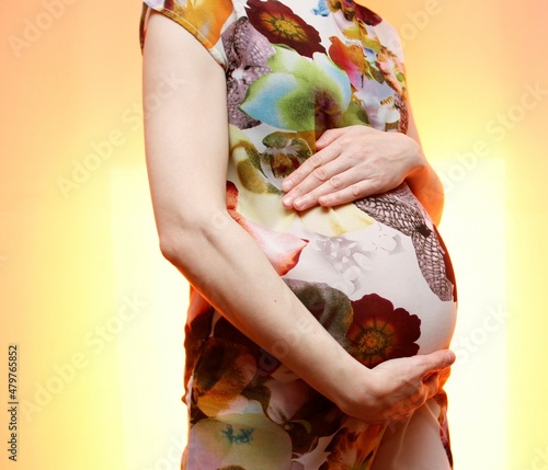 pregnant girl stands hugging her belly