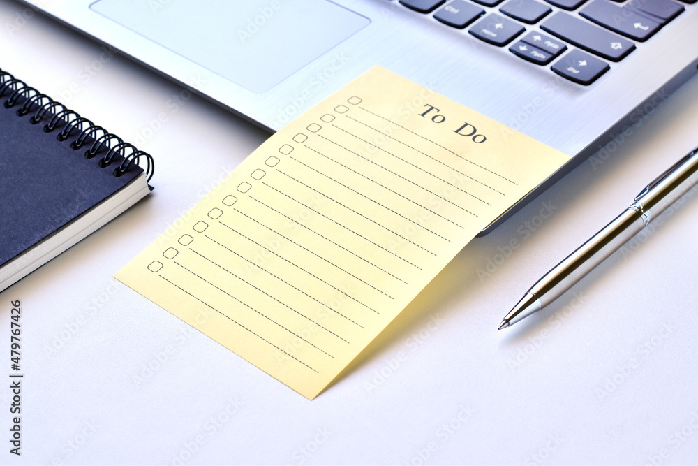 Paper note to do list on laptop with pen and black book. Paper note to do list on laptop with pen and black book.