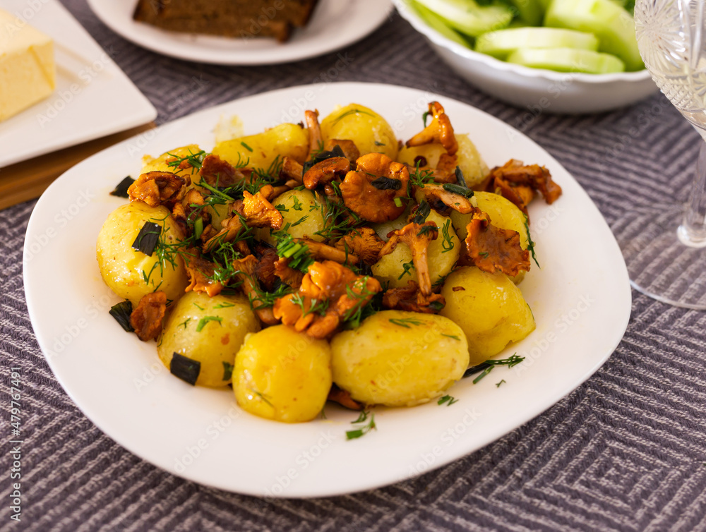 baked potatoes with chanterelles, served with herbs on white plate baked potatoes with chanterelles, served with herbs on white plate