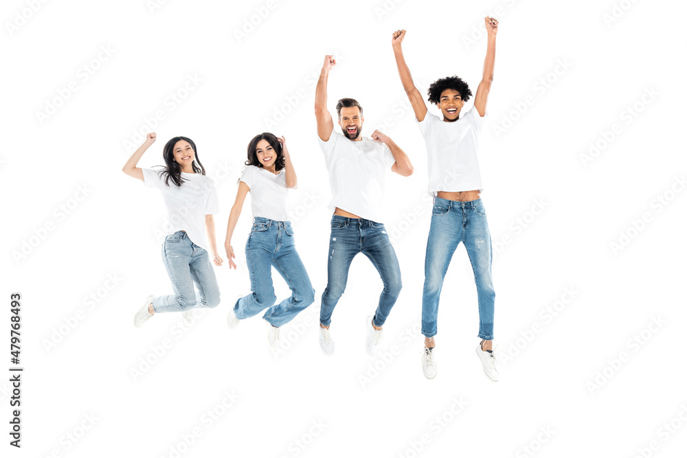 full length view of excited multicultural friends in jeans showing win gesture while levitating isolated on white. full length view of excited multicultural friends in jeans showing win gesture while levitating isolated on white.