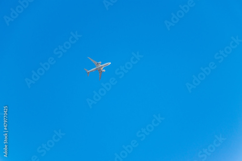 真っ青な空を飛ぶ白い飛行機