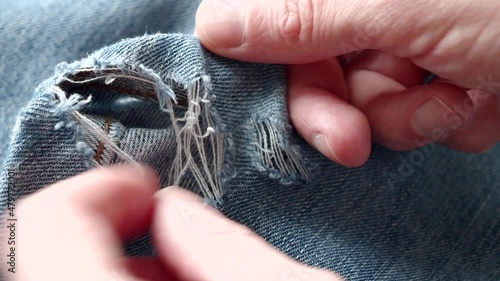 Man explore hole in ripped jeans before sew up it. Close-up of video 4k resolution