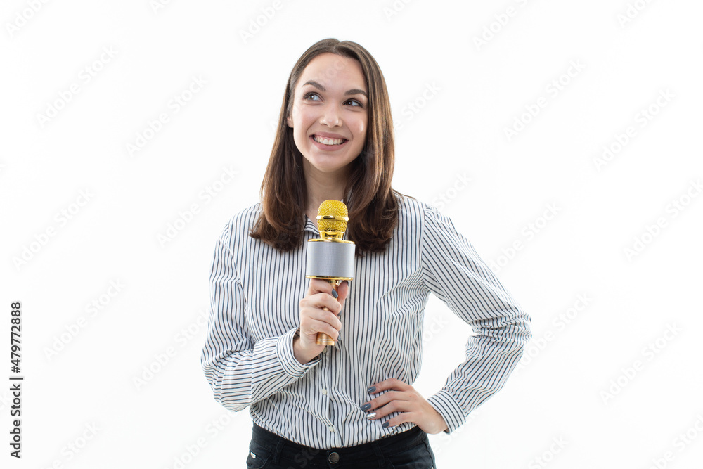 Smiling brunette sings into a microphone on a white background Smiling brunette sings into a microphone on a white background