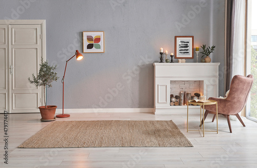 Slika na platnu Modern room concept interior style, chair fireplace frame wicker carpet decoration, grey stone wall background