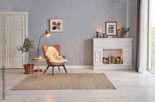 Valokuva Modern room concept interior style, chair fireplace frame wicker carpet decoration, grey stone wall background