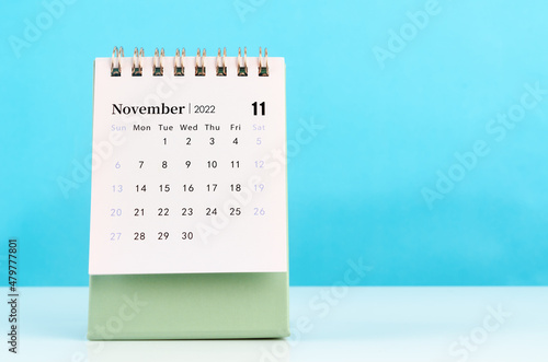 November 2022 desk calendar on blue background.