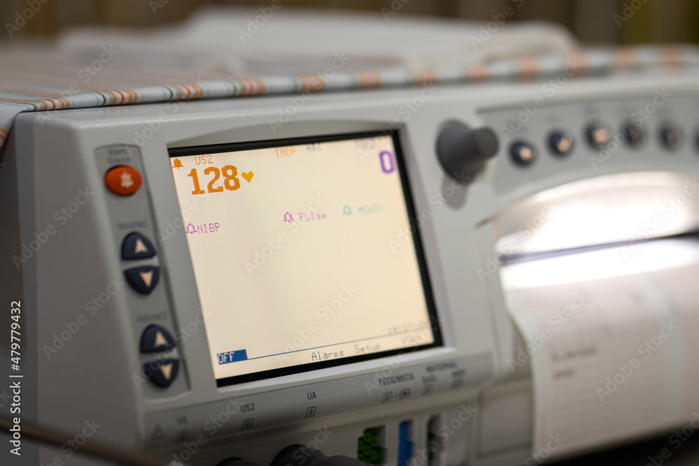 Fototapeta premium Electrocardiogram monitoring which is using to monitor heart pulse of a patient. Healthcare and medical object photo. Partial focus at the number of pulse rate on screen.