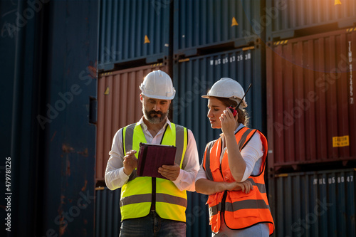 male engineer holding a tablet, consults and inspects a container with a female worker's colleague about the problem of container transportation in the container yard. 