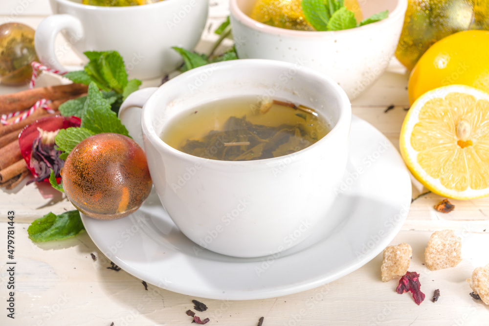 Various tea ball bombs. Assortment of different tea balls with dried tea, cups, lemon and mint, top view copy space. Trendy modern tea variety Various tea ball bombs. Assortment of different tea balls with dried tea, cups, lemon and mint, top view copy space. Trendy modern tea variety