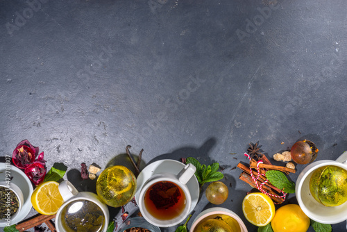 Various tea ball bombs. Assortment of different tea balls with dried tea, cups, lemon and mint, top view copy space. Trendy modern tea variety photo